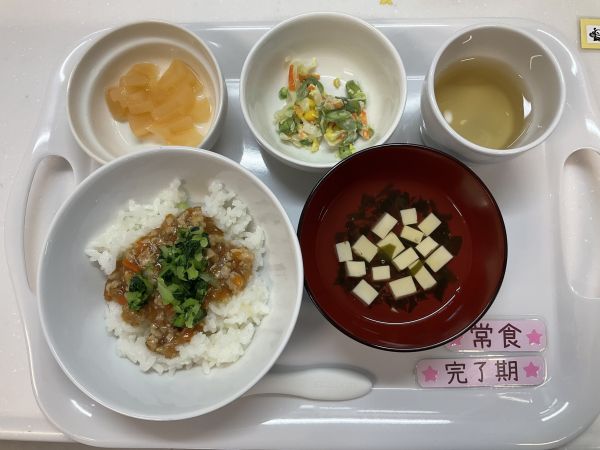 《離乳食完了期常食》給食は鶏挽き肉と小松菜の丼　キャベツとコーンのコールスロー　すまし汁　桃缶です。