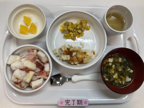 《離乳食完了期》給食は米粉パン　かじきのステーキ　コーンと人参入りアスパラソテー　すまし汁　オレンジです。